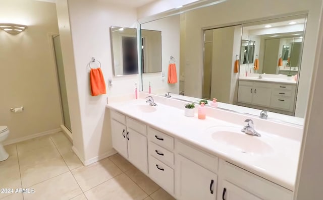 bathroom with a shower with door, tile patterned flooring, vanity, and toilet