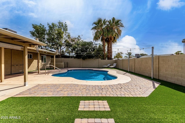 view of pool with a lawn and a patio