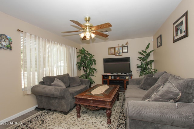 living room featuring a ceiling fan, visible vents, and baseboards