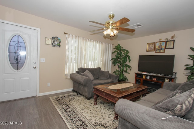 living room featuring baseboards, ceiling fan, visible vents, and wood finished floors