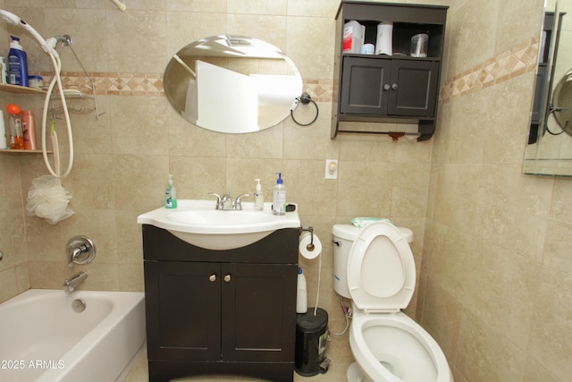 bathroom featuring toilet, tub / shower combination, tile walls, and vanity