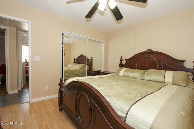 bedroom featuring baseboards, light wood-style flooring, a ceiling fan, and a closet