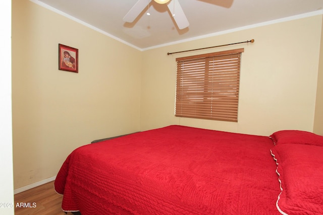 bedroom featuring ornamental molding, ceiling fan, baseboards, and wood finished floors