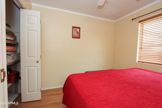 bedroom with light wood finished floors, ceiling fan, ornamental molding, and baseboards