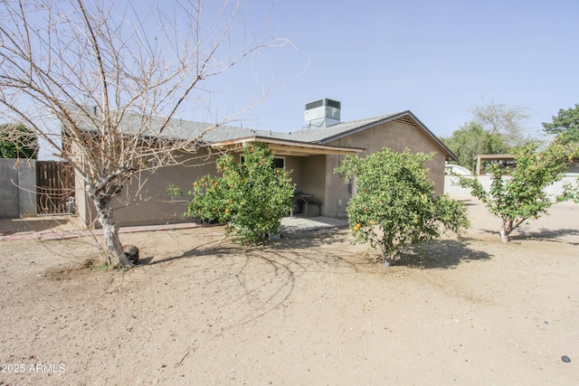 view of front of property with central air condition unit, fence, and stucco siding