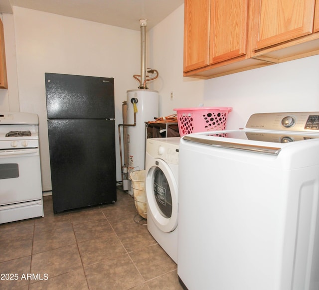 washroom featuring water heater, laundry area, washing machine and dryer, and tile patterned floors