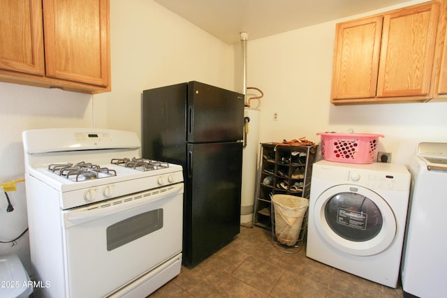 kitchen featuring dark tile patterned floors, gas range gas stove, washing machine and clothes dryer, and freestanding refrigerator