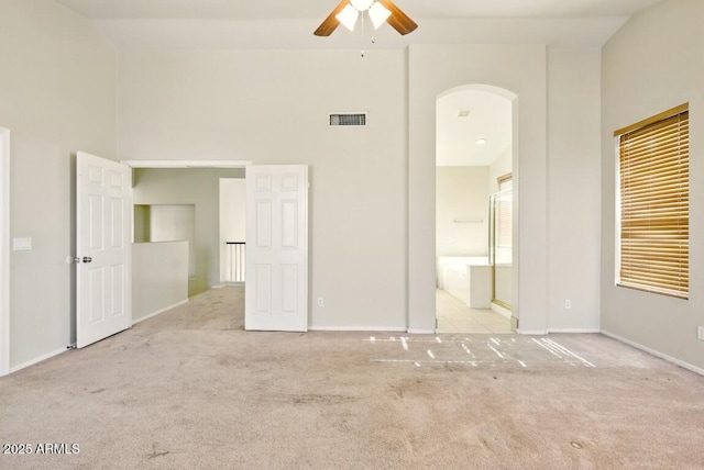 2880 E Nunneley Rd, Gilbert, AZ 85296 - unfurnished bedroom with carpet flooring, arched walkways, a high ceiling, baseboards, and connected bathroom