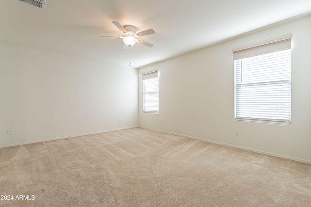 spare room featuring ceiling fan and light carpet