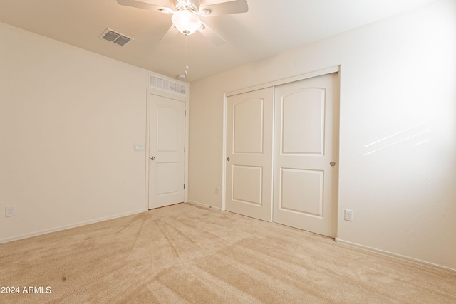 unfurnished bedroom with light carpet, a closet, and ceiling fan