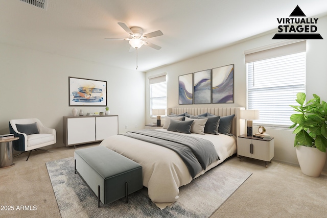 bedroom featuring ceiling fan, light colored carpet, and multiple windows