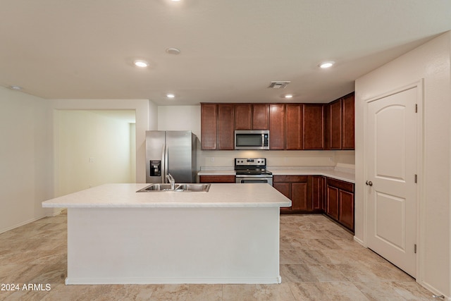 kitchen featuring appliances with stainless steel finishes, sink, and an island with sink