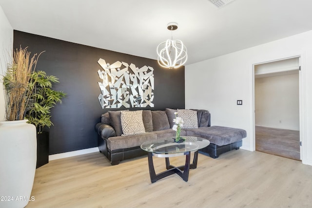 living room with light hardwood / wood-style flooring and a notable chandelier