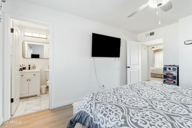 bedroom featuring connected bathroom, ceiling fan, and light wood-type flooring