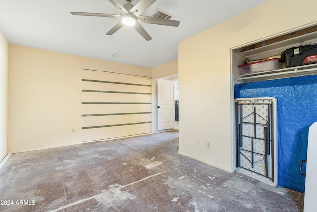 unfurnished bedroom with ceiling fan and a closet