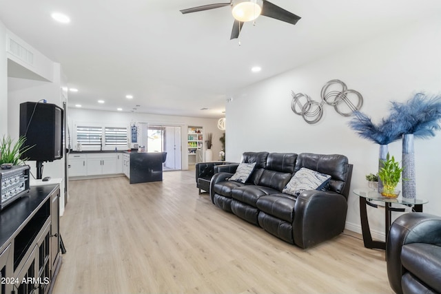 living room featuring light hardwood / wood-style flooring and ceiling fan