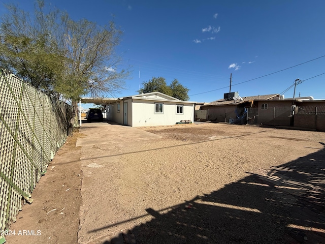 back of house featuring a carport