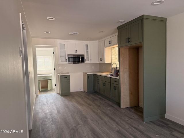 kitchen featuring backsplash, dark hardwood / wood-style floors, white cabinetry, and sink