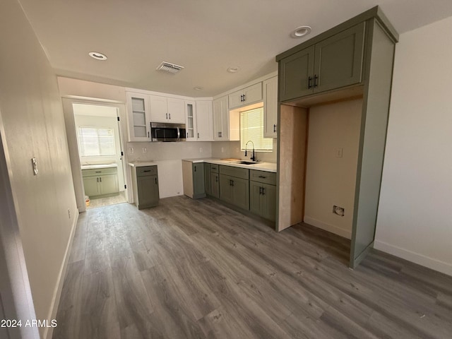 kitchen featuring white cabinetry, hardwood / wood-style floors, and sink