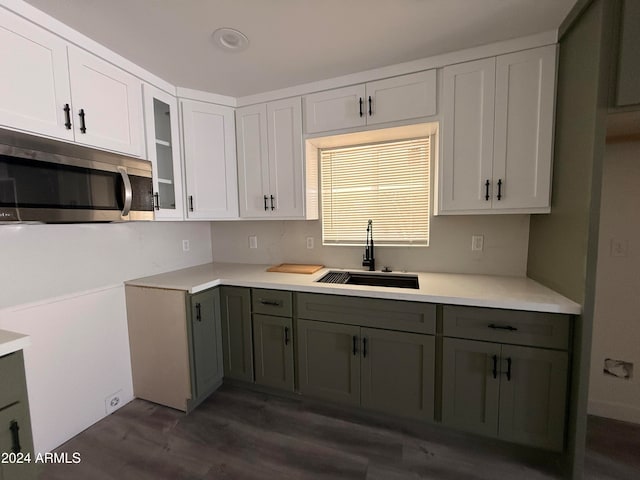 kitchen with dark hardwood / wood-style floors, white cabinetry, and sink