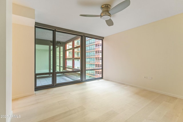 4808 N 24th St Unit 923, Phoenix, AZ 85016 - empty room with expansive windows, ceiling fan, and wood finished floors
