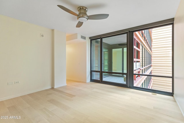 4808 N 24th St Unit 923, Phoenix, AZ 85016 - unfurnished room featuring wood finished floors, plenty of natural light, a ceiling fan, and a wall of windows