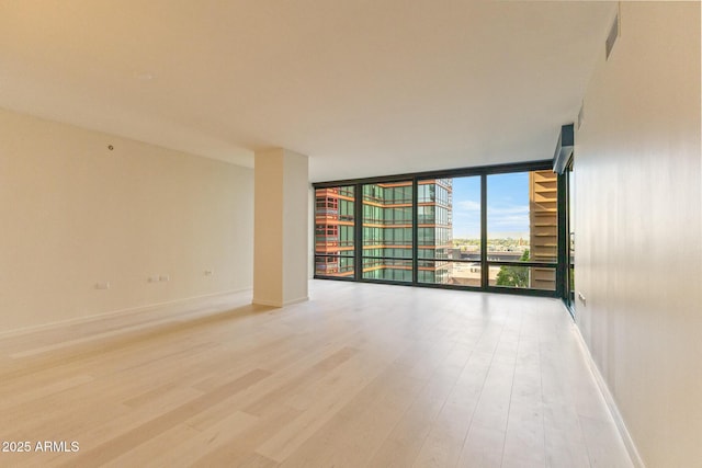 4808 N 24th St Unit 923, Phoenix, AZ 85016 - empty room with a wall of windows, light wood-type flooring, and a city view