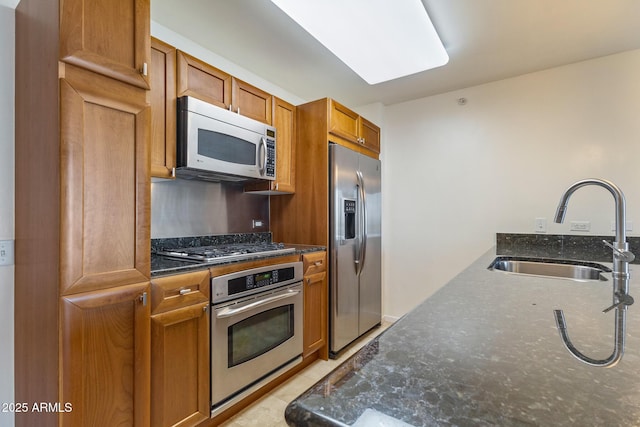 4808 N 24th St Unit 923, Phoenix, AZ 85016 - kitchen with appliances with stainless steel finishes, brown cabinets, and dark stone counters
