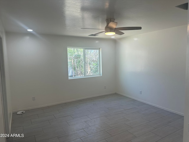 empty room with ceiling fan and light hardwood / wood-style floors