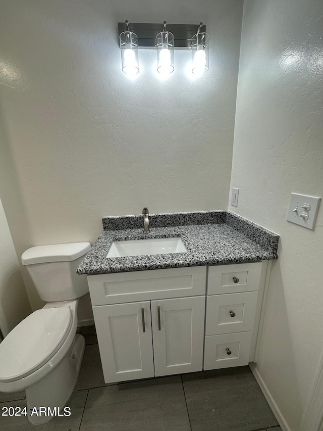 bathroom with tile patterned flooring, vanity, and toilet