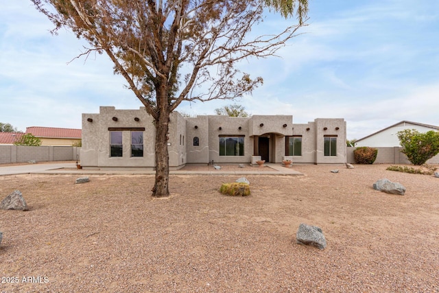 rear view of property with stucco siding and fence