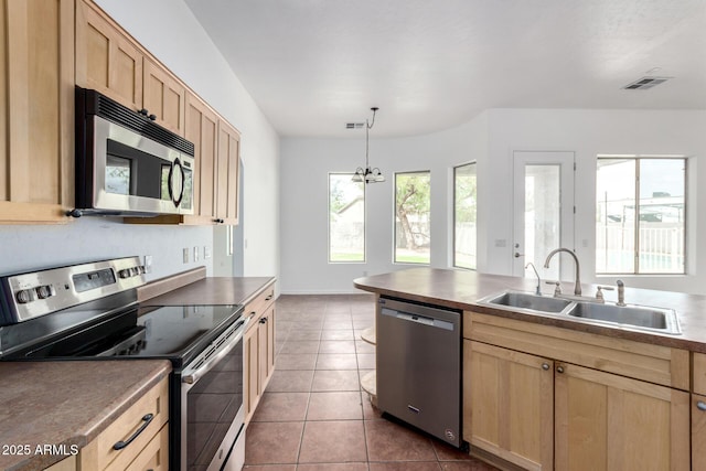 kitchen featuring tile patterned flooring, visible vents, a sink, stainless steel appliances, and light brown cabinets