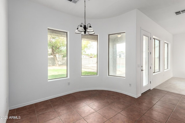 unfurnished dining area with baseboards, a notable chandelier, dark tile patterned floors, and visible vents