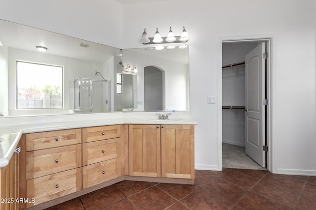 bathroom with vanity, a stall shower, tile patterned flooring, a walk in closet, and visible vents
