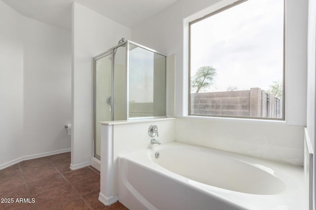 full bath featuring a shower stall, tile patterned floors, baseboards, and a garden tub