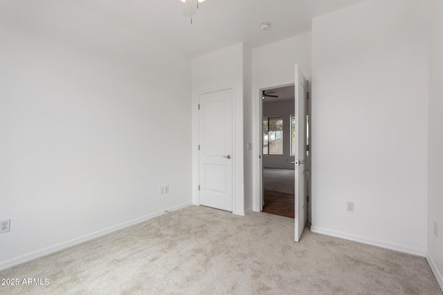 unfurnished bedroom featuring light colored carpet and baseboards