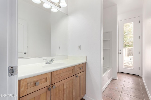 full bath with a tub, tile patterned floors, vanity, and baseboards