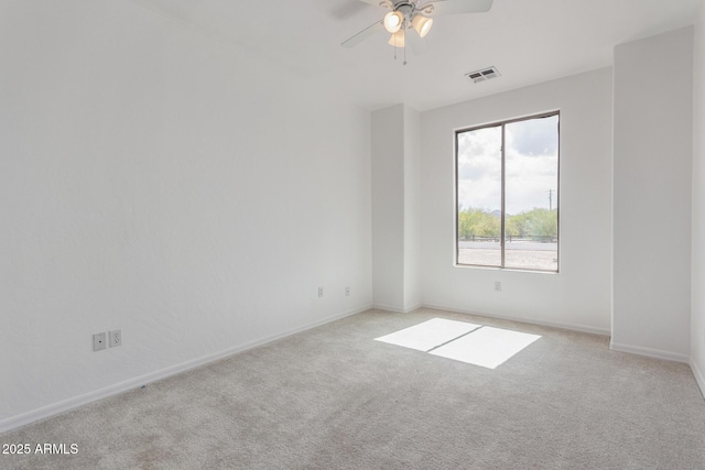 spare room featuring carpet flooring, visible vents, baseboards, and ceiling fan
