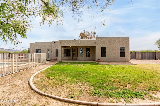 back of property with a patio area, stucco siding, a fenced backyard, and a lawn