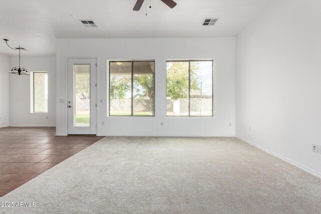 unfurnished living room featuring ceiling fan with notable chandelier, visible vents, and carpet floors