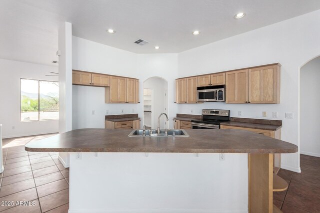 kitchen with a sink, visible vents, dark countertops, and stainless steel appliances