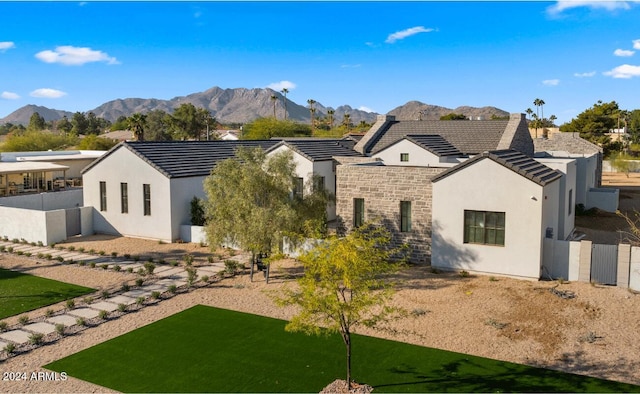 back of property featuring a yard and a mountain view