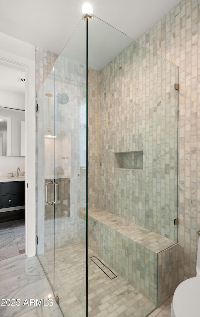 bathroom featuring walk in shower and vanity