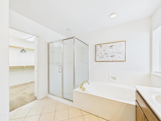full bathroom featuring a shower stall, a bath, a spacious closet, and tile patterned flooring