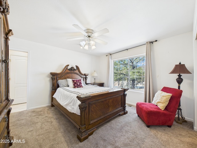 bedroom featuring light carpet, baseboards, and a ceiling fan