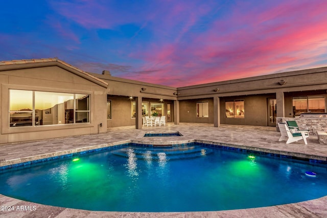 pool at dusk with a patio