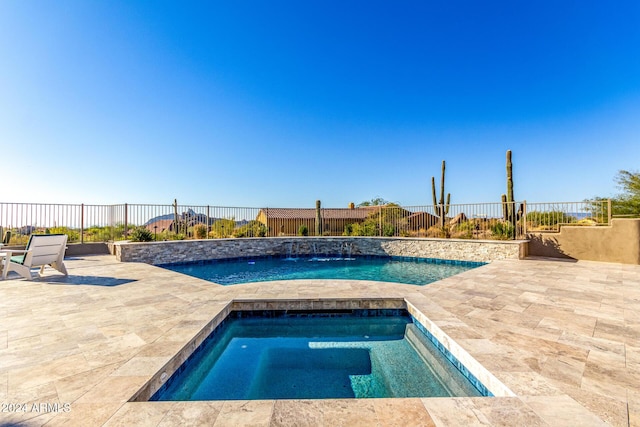 view of pool with an in ground hot tub, pool water feature, and a patio area