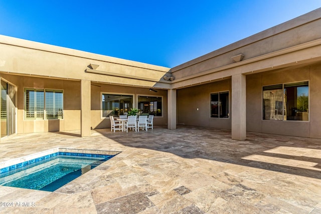 back of house featuring a patio area and a hot tub