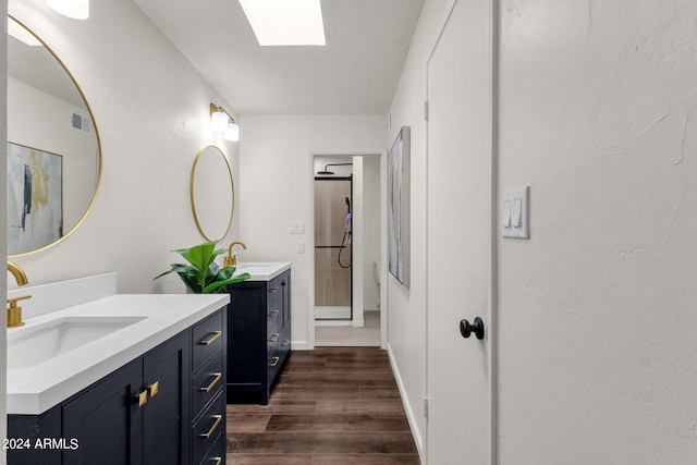 bathroom featuring a skylight, hardwood / wood-style flooring, and vanity