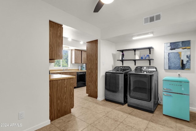 kitchen featuring washer and clothes dryer, light tile patterned floors, dishwasher, sink, and ceiling fan